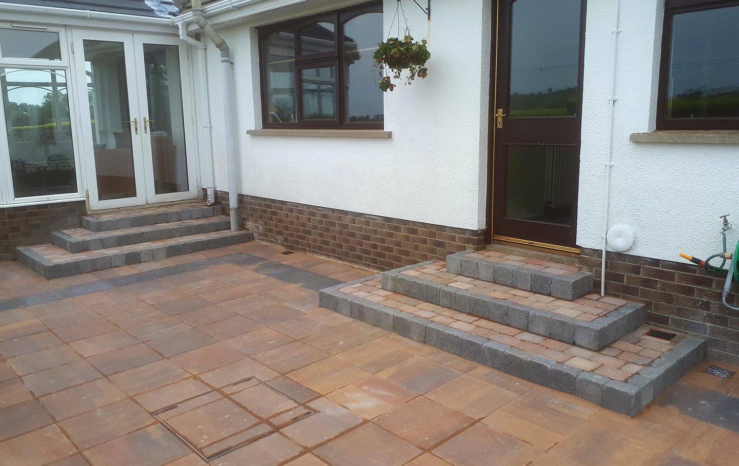 Newly laid paving stones with steps leading to the doors of the house